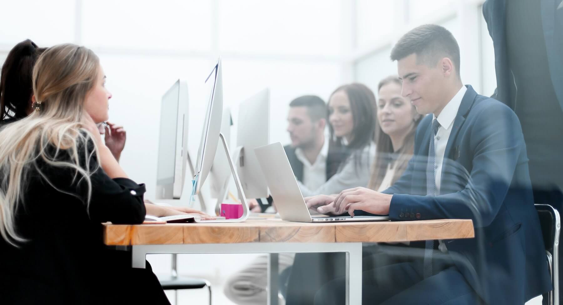 Employees using computers in a monitored modern workplace